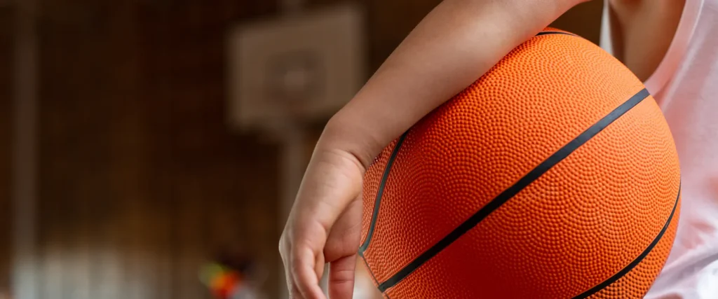 Youth with basketball under arm.